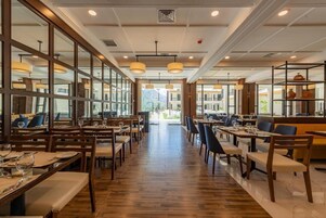 Un restaurante espacioso con suelo de madera, varias mesas y sillas.