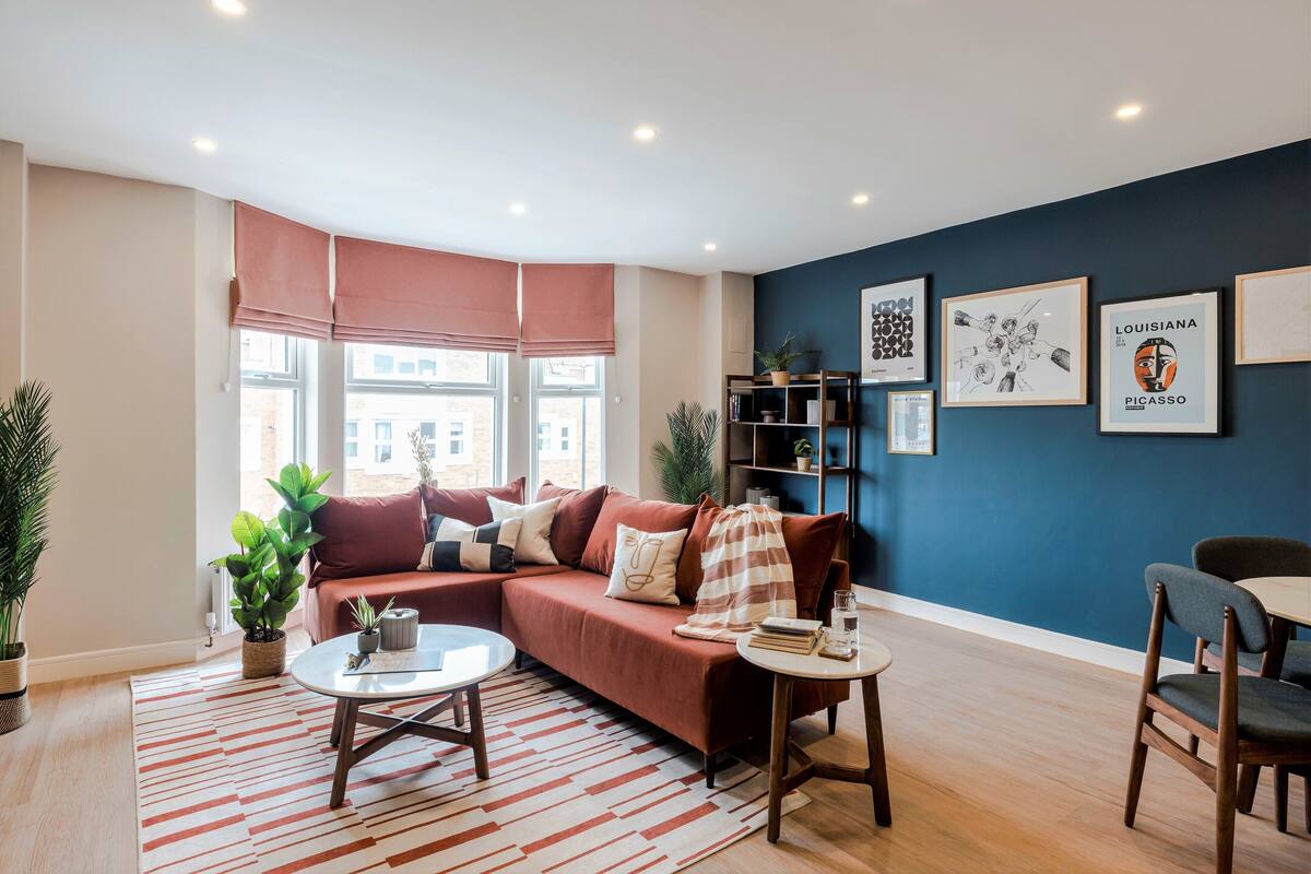 A modern living room with a sofa, coffee table, and bookshelf.