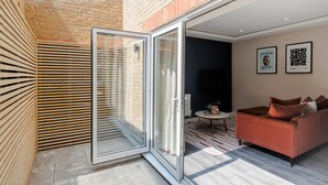 Una sala de estar moderna con un ventanal corredero que da a un patio.