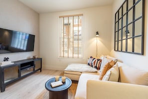 Relax in this stylish living room with a flat-screen TV, entertainment unit, and comfortable sofa.