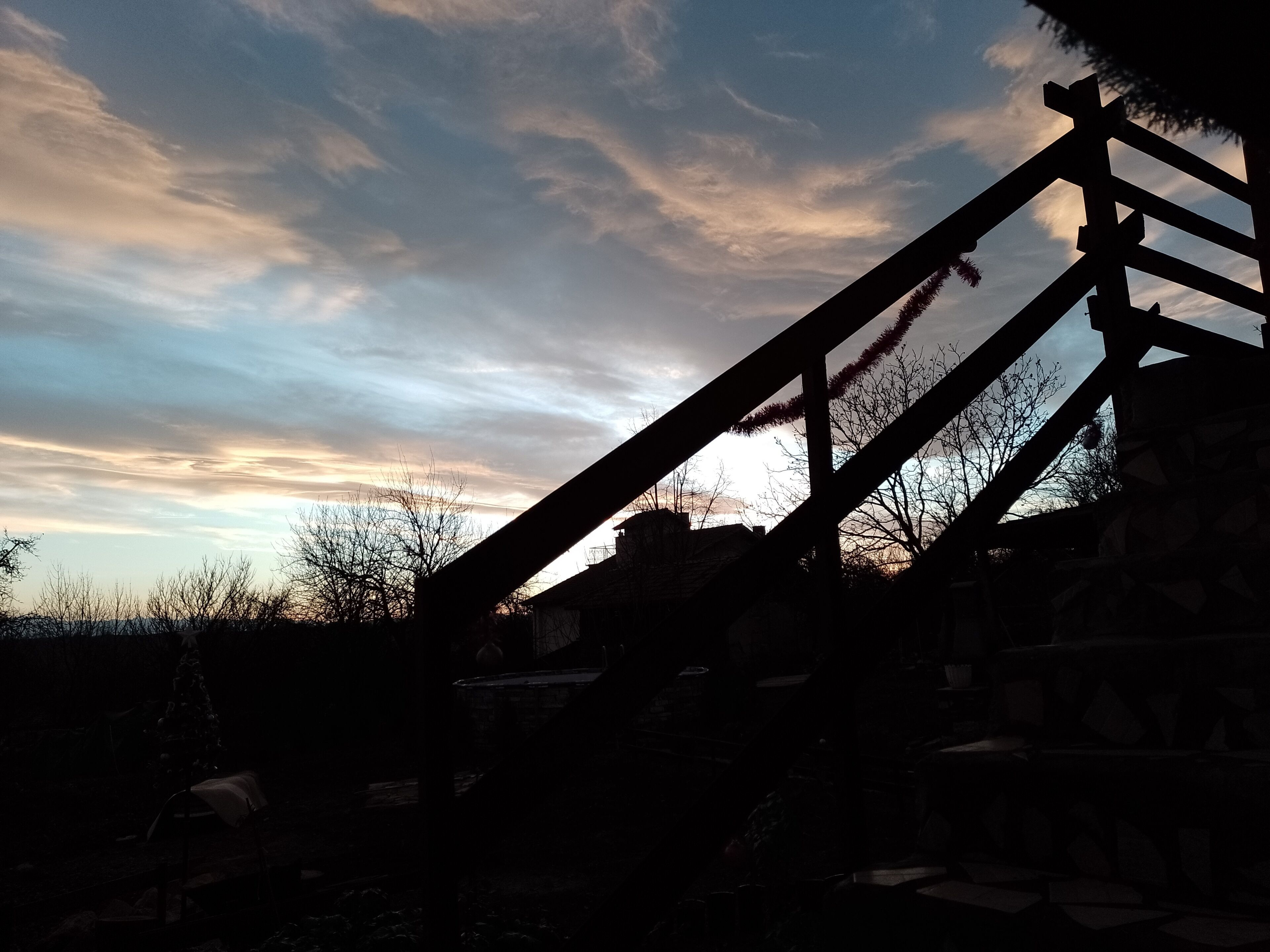 Silueta de una estructura de madera contra un cielo al atardecer.