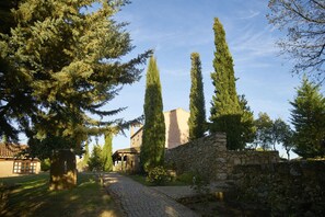Un sentier pavé de pierres menant à un mur de pierre et à un bâtiment dont le toit est recouvert de tuiles.