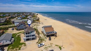 Zona residencial costera con casas, una playa y un letrero de COVE REALTY.