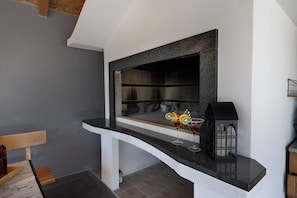 A modern kitchen with a curved countertop, a built-in oven, and a black lantern on the shelf.