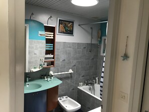 Regadera, bidet, papel de baño 