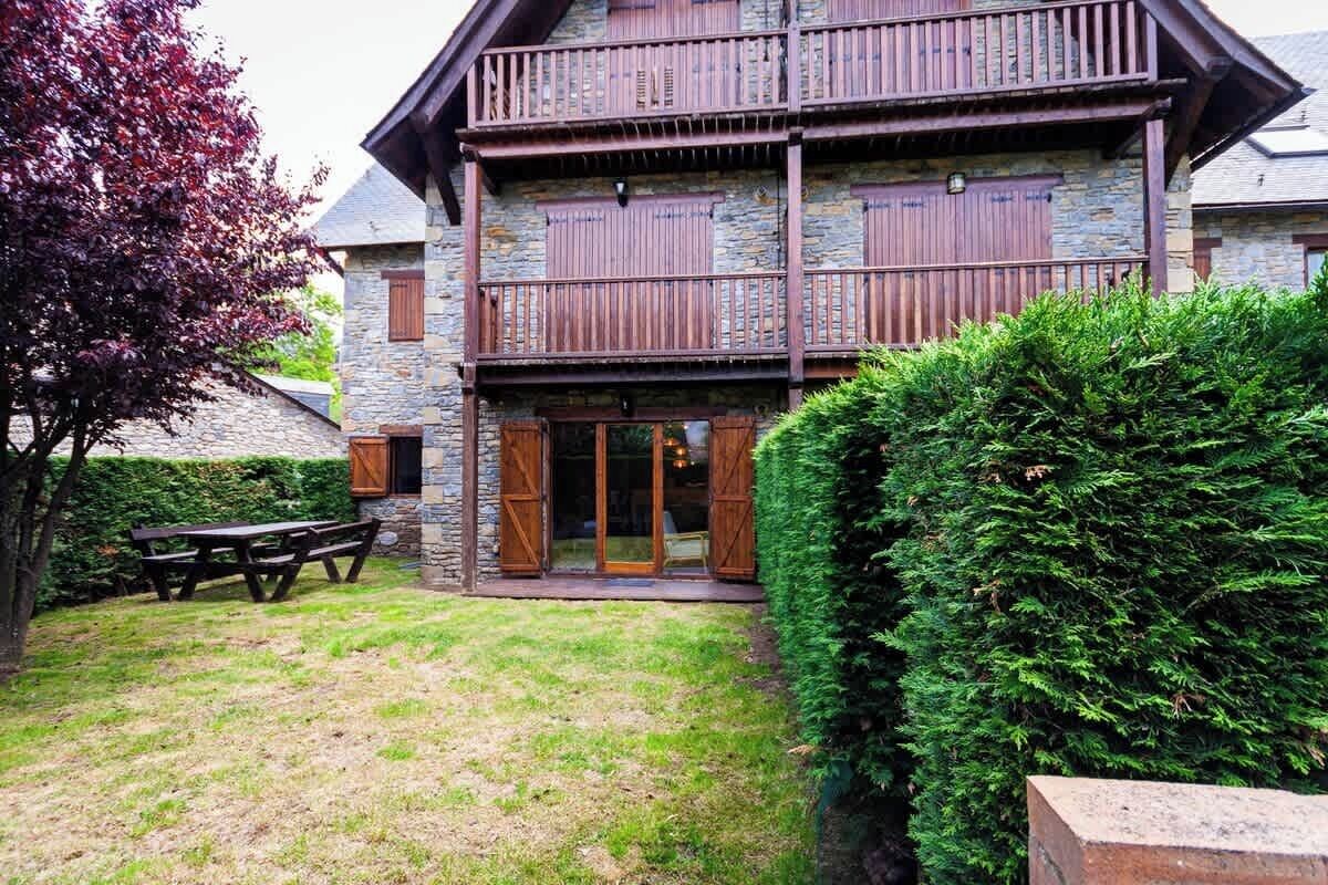 Un bâtiment en pierre de deux étages, doté de balcons en bois et d’une façade en pierre.