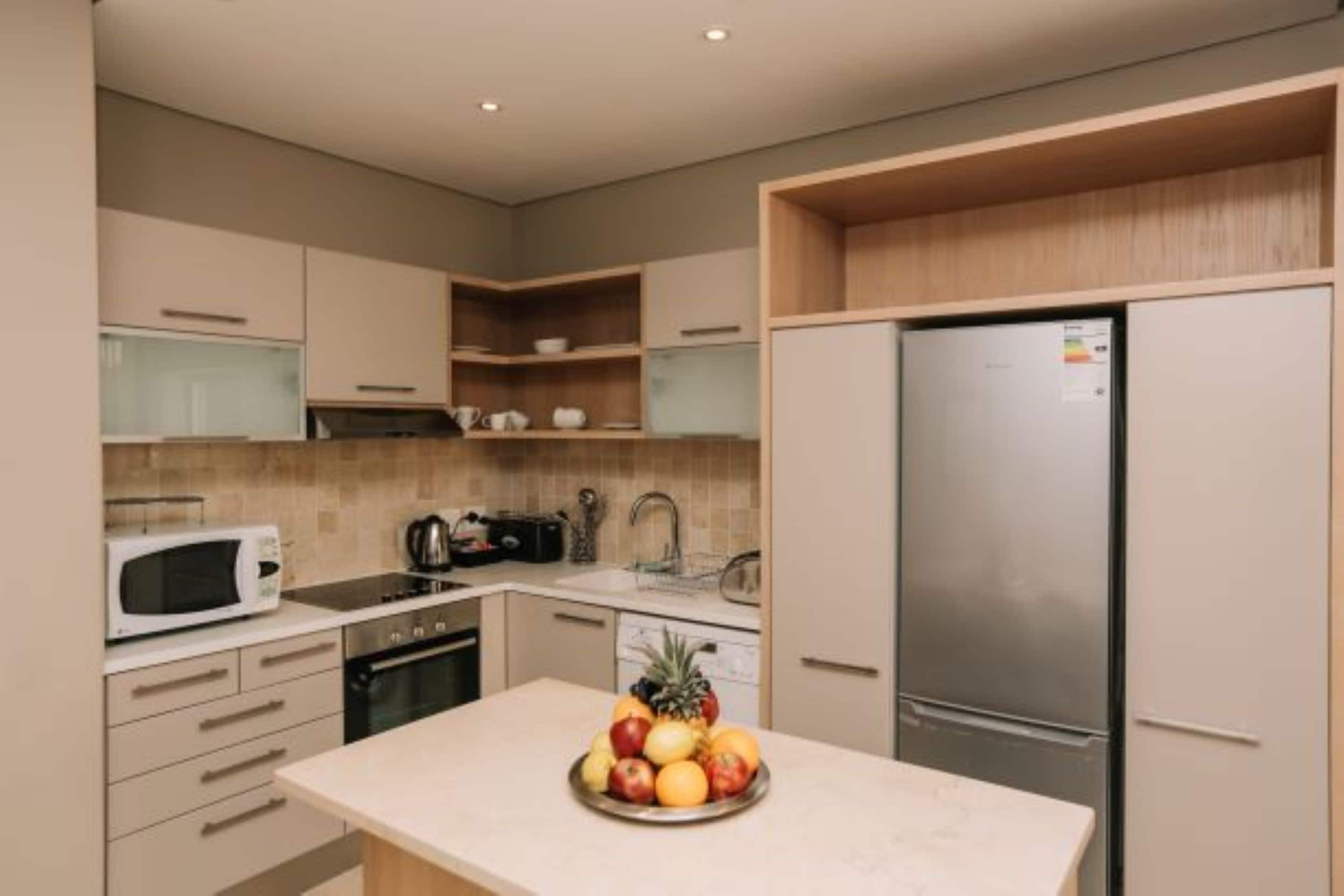 A modern kitchen with a stainless steel refrigerator, a microwave, and a sink.