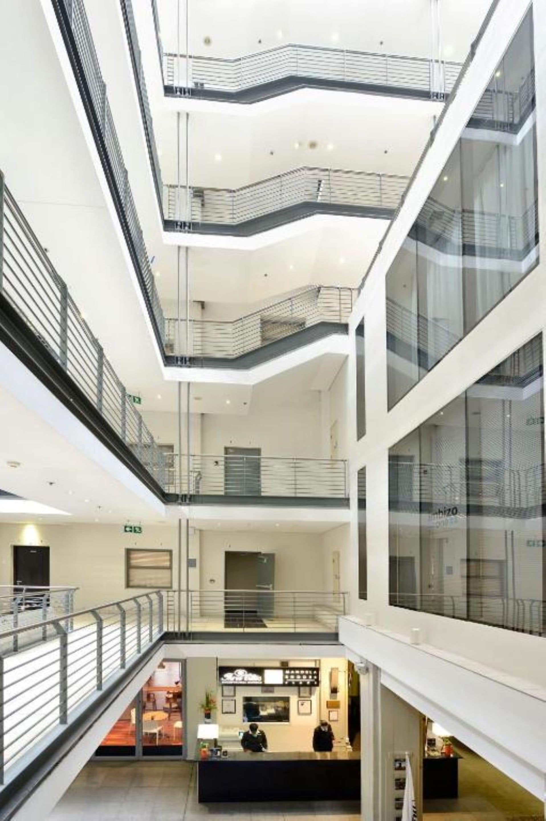 A multi-level atrium with glass railings and a reception desk.
