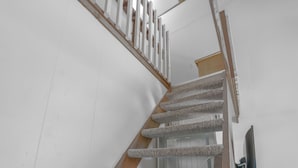 Eine Treppe mit Holzhandlauf und Teppichstufen.