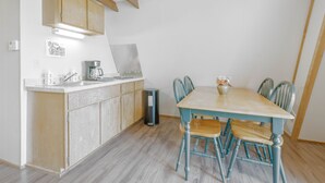 Eine Küche mit Holzschränken, einer Kaffeemaschine und einem Mülleimer.