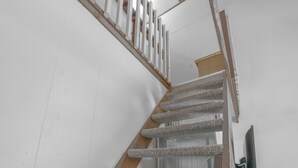 Eine Treppe mit Holzhandlauf und Teppichstufen.