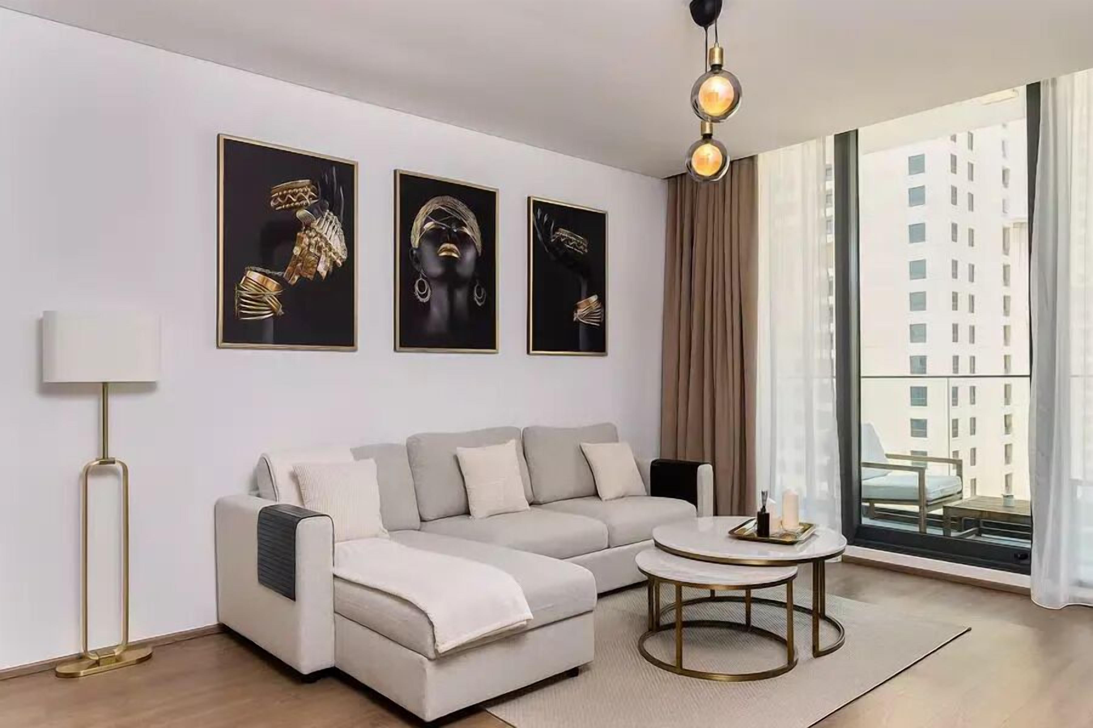 Ein modernes Wohnzimmer mit einer Couch, einem Couchtisch und Kunstwerken an der Wand.
