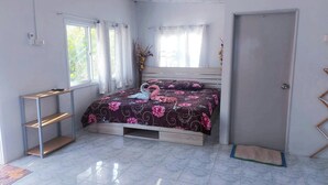 Un dormitorio con cama, ventana, puerta y estantería.