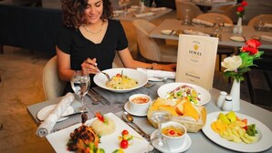 Una tavola imbandita con diversi piatti, un menu e un vaso di fiori.