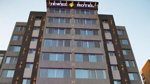 Un hotel a più piani con un cartello ben visibile con la scritta "JEWEL HOTEL" sulla sommità.