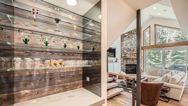 A modern kitchen with wooden shelves and glass containers, a dining area with a stone wall, and a cozy living room with a large window. - 1890 Lions Ridge Loop, #9-West Vail Remodeled Home, Hot Tub, On Bus Route, Close to Vail! (Vail)