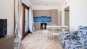 A modern apartment with a kitchen, dining area, and living room.