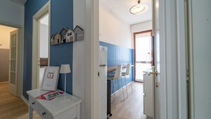 Una cucina moderna con piastrelle blu, un frigorifero bianco e un'area da pranzo con tavolo e sedie.