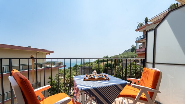 Un balcone con un tavolo apparecchiato per due persone, con vista su un panorama suggestivo.