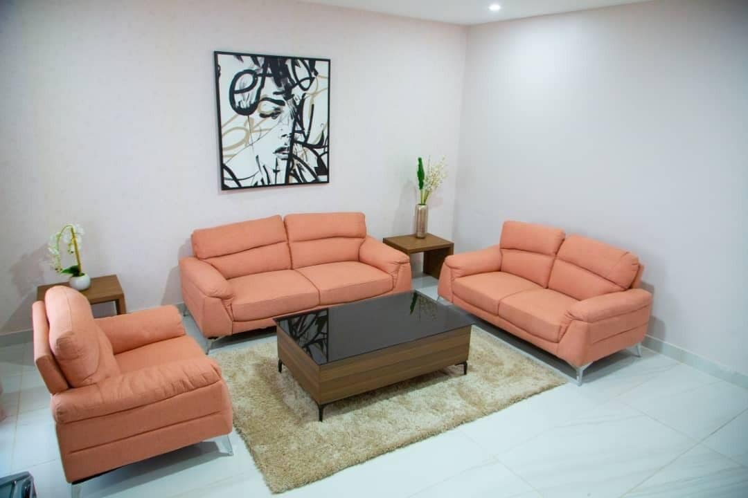 A living room with a sofa set, a coffee table, and a small side table with a vase.