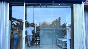 A hotel entrance with a glass door, a visible bed inside, and a view of the street outside. - Sagar Dormitory Andheri - Nearest to Andheri Railway Station West (Mumbai)
