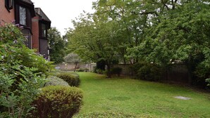 Un jardin bien entretenu, agrémenté d’une haie, d’une pelouse et d’un mur en briques.