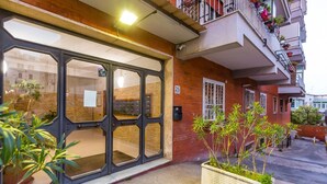 A building with a large glass door, a balcony with potted plants, and a number '25' sign on the wall. - Appartamento all Arenella by Wonderful Italy (Naples)