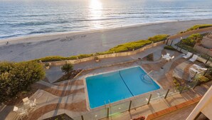 Ein Poolbereich mit Blick auf Strand und Meer.