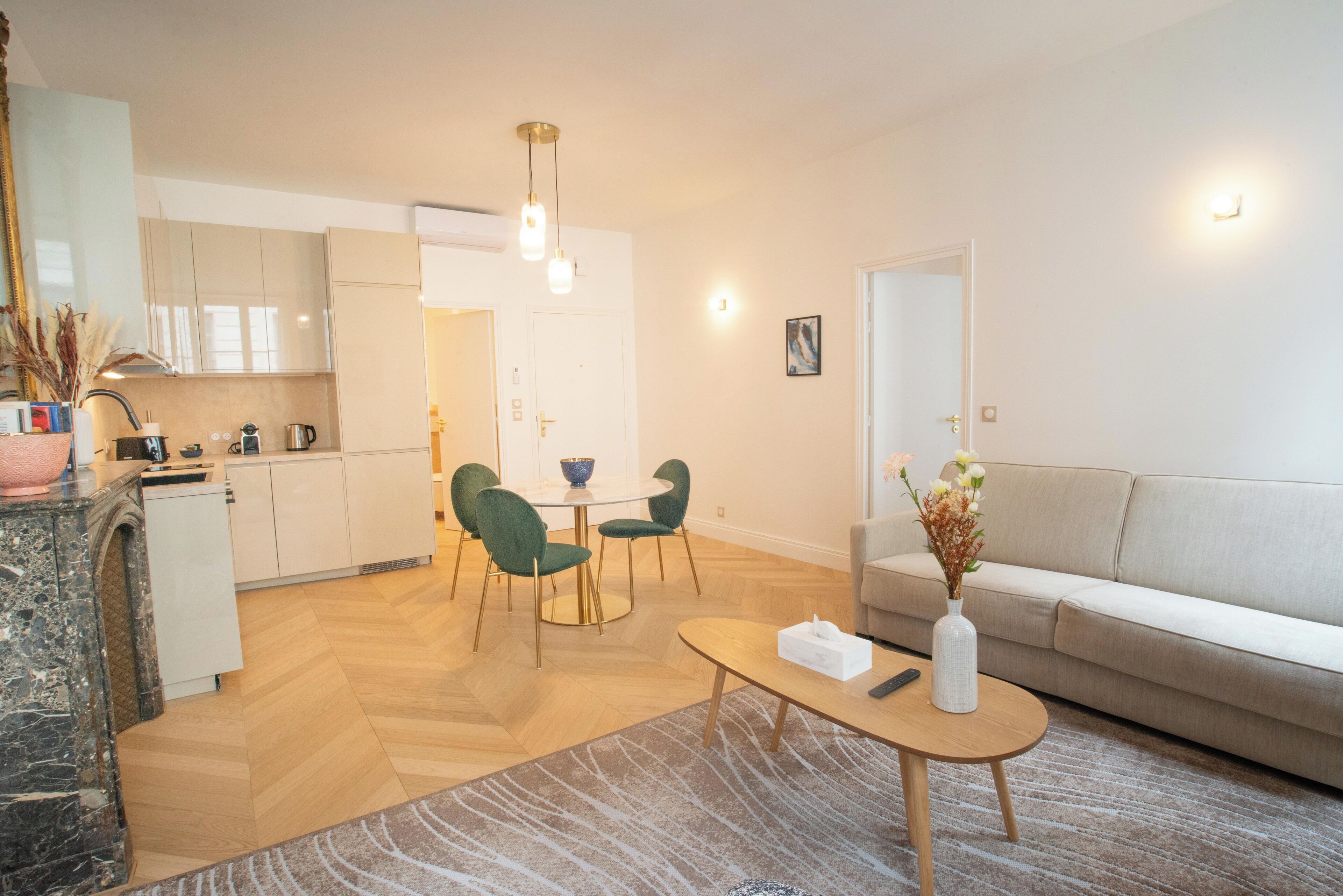 A modern living room with a sofa, a coffee table, and a dining area with chairs and a table.