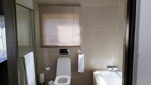 Un baño moderno con inodoro, bidé y bañera.