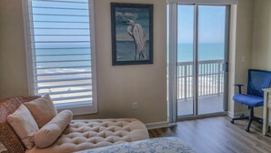 A bedroom with a large window, a painting of a bird, a bed, and a chair. - Oceanfront condo with full access to all resort amenities, 1104 Margate!! (Myrtle Beach)