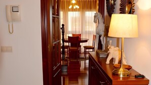 Habitación de hotel con puerta de madera, teléfono, lámpara y comedor con candelabro.