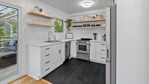Eine moderne Küche mit weißen Schränken, einem eingebauten Backofen und einem Kühlschrank.