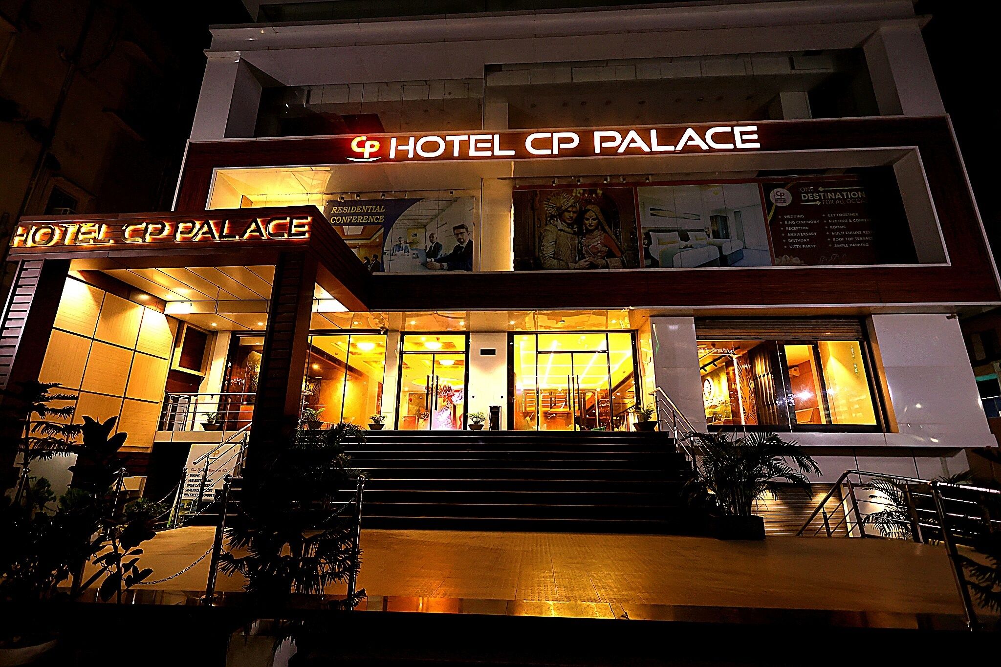 Un hotel con un letrero llamativo que dice 'HOTEL CP PALACE' y una entrada visible con escalones que conducen a las puertas.