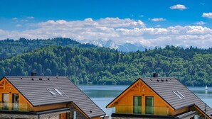 Two wooden cabins with sloped roofs, a clear view of a lake, and a forested mountain range in the background. - Czorsztyn Prestige (Czorsztyn)
