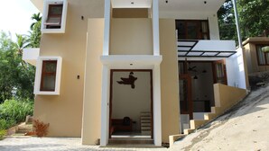 A modern two-story building with a flat roof, a balcony, and a staircase leading to the upper level. - Kandy Lotus Villa (Kandy)