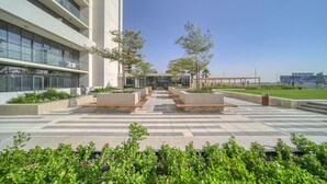 Een modern gebouw met een zwart-wit schaakbordvloer, terras en beplanting.