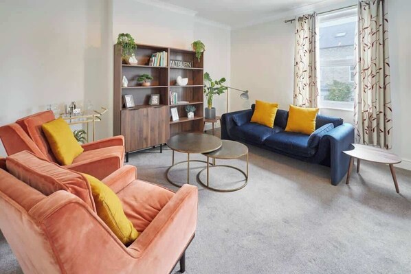 A living room with a sofa set, a coffee table, and a bookshelf.