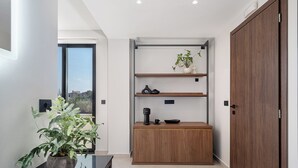 A modern kitchen with a wooden cabinet, a black countertop, and a potted plant. - Theta Boutique Hotel (Chania)