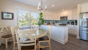 Una cocina moderna con armarios blancos, una isla central y electrodomésticos de acero inoxidable.