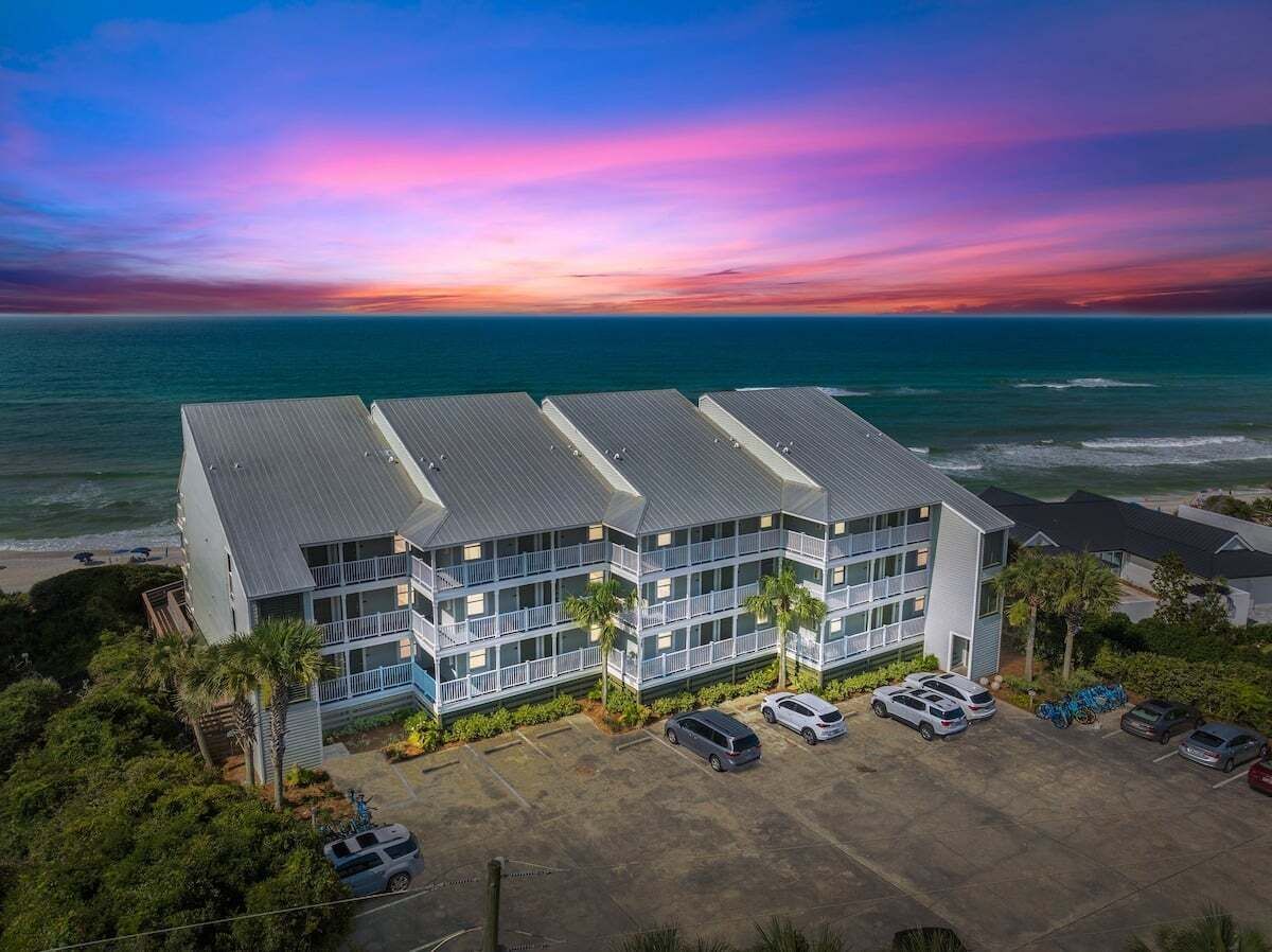 Een hotel met meerdere verdiepingen, balkons, parkeergelegenheid en uitzicht op de oceaan.