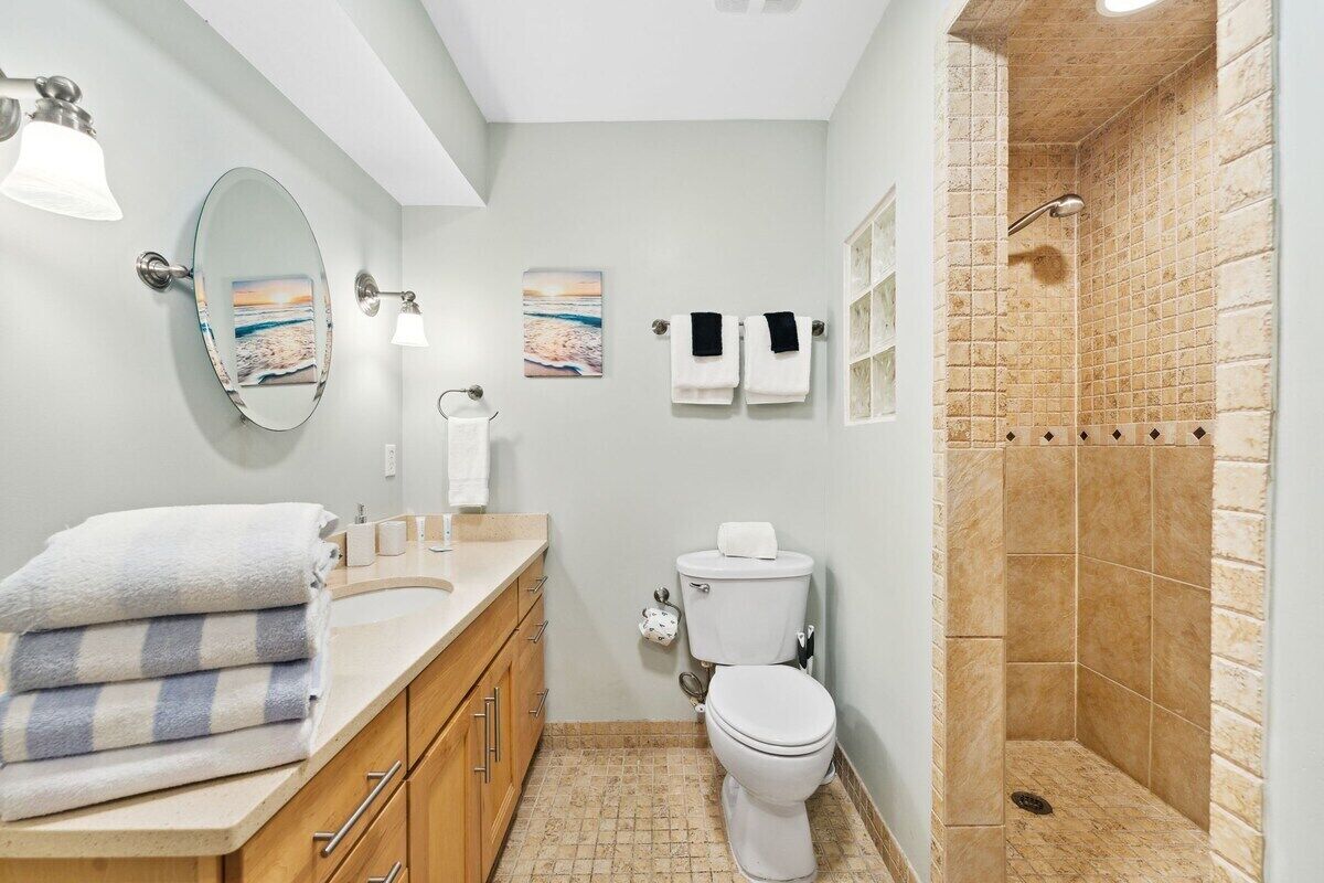A bathroom with a shower, toilet, and vanity.
