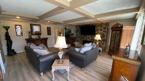 A spacious living room with two sofas, a coffee table, a fireplace, and a television mounted on the wall. - Toad Hall Manor  (Butte)