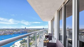 A balcony with a view of a marina and cityscape.