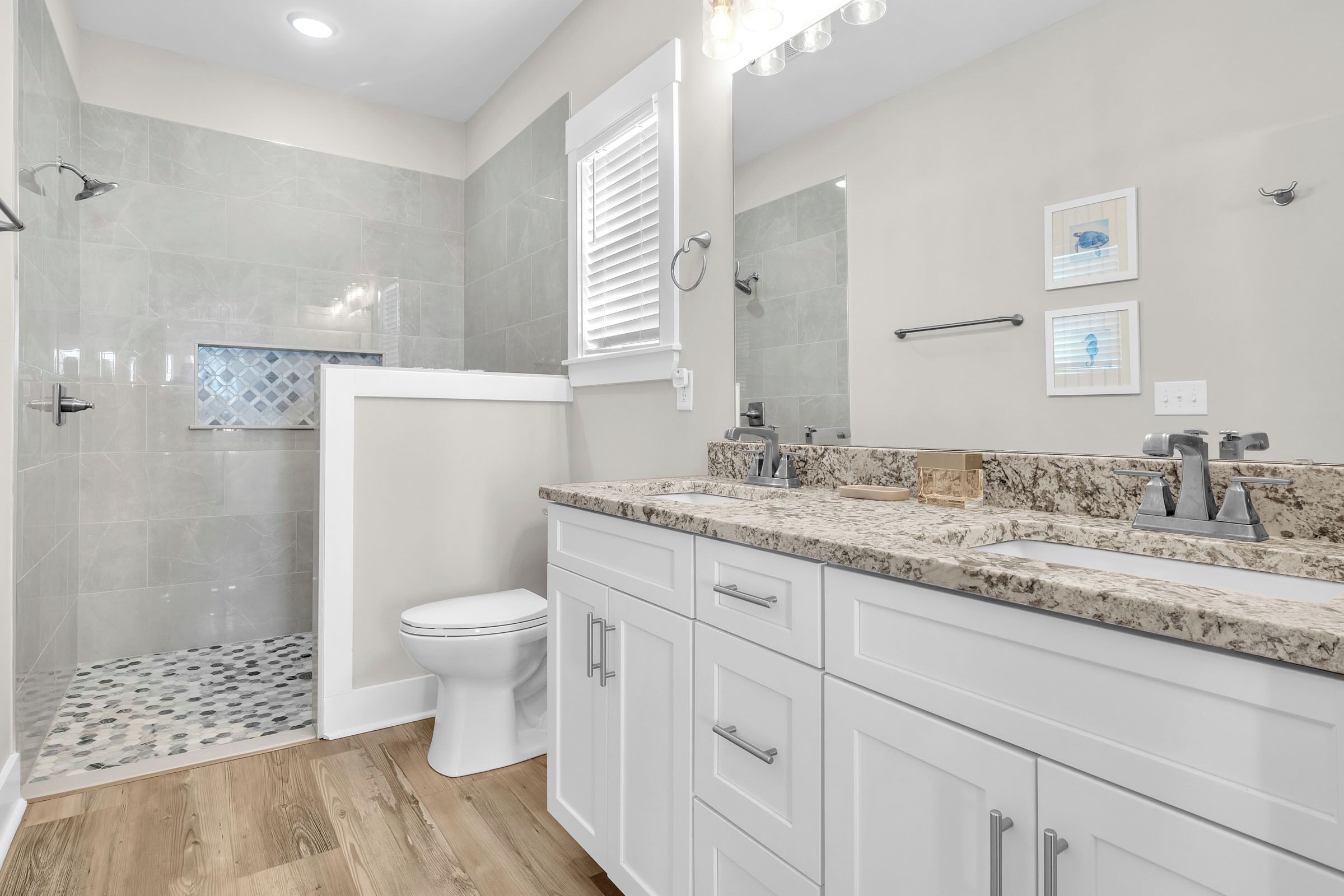 A modern bathroom with a shower, toilet, and vanity with a sink.