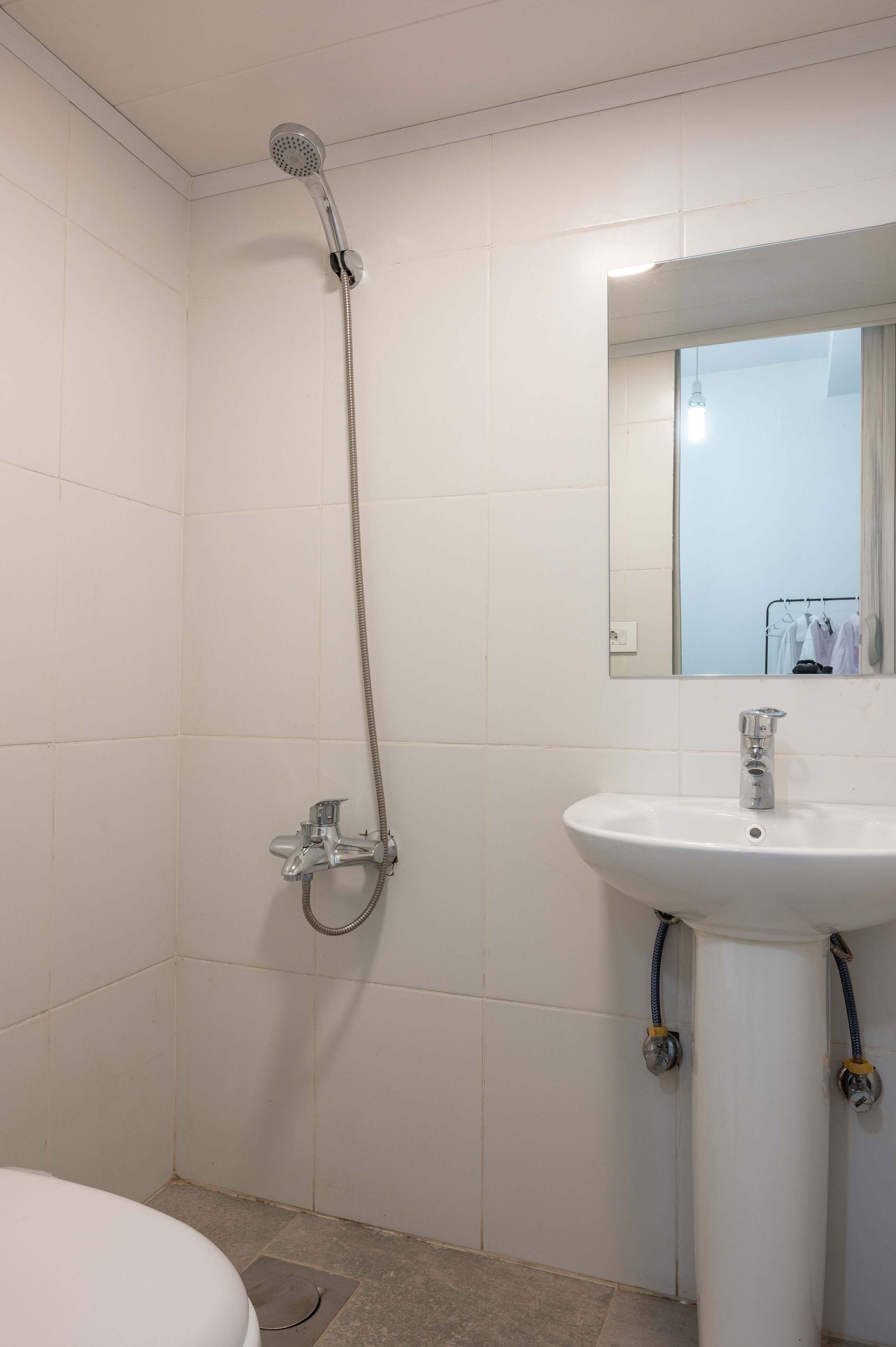 Un baño con ducha, lavabo y espejo.