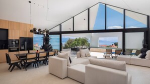 En moderne stue med et køkken, spiseområde og en balkon med udsigt.