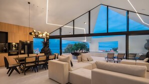 Et moderne interiør med spiseplads, sofaer og et køkken.