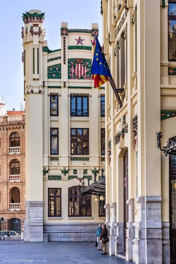 A historic building with a prominent star and shield emblem, a flagpole with the European Union flag, and a classic architectural style with ornate details. - SMALL PENTHOUSE (1 bedroom) (València)