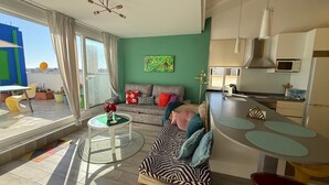 Un appartement moderne comprenant un salon, une cuisine et un balcon.